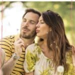 A couple blowing a dandelion together with the text overlay Spring date ideas for couples