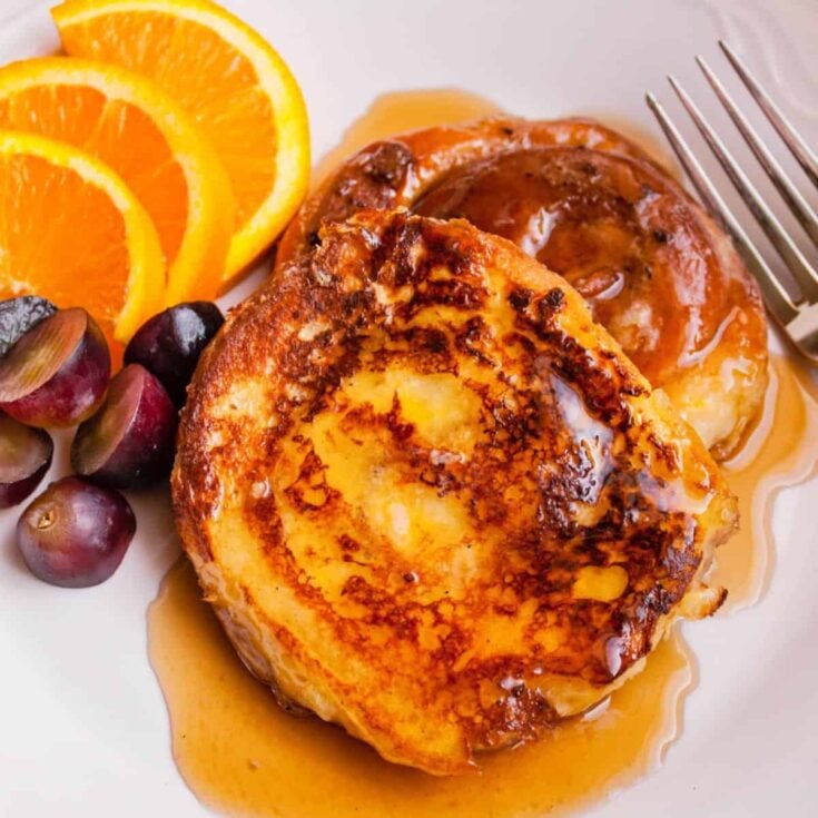 Cinnamon roll French toast with slices of orange and grapes