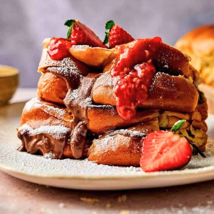 Nutella and dark chocolate stuffed French toast topped with sliced strawberries